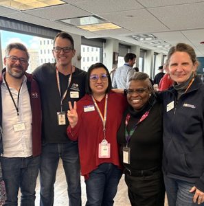 Group of staff standing together and smiling at a workplace event